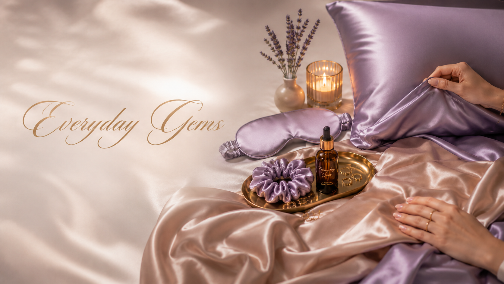 Elegant bedroom scene with lavender silk sheets, gold tray with beauty essentials, and Everyday Gems branding
